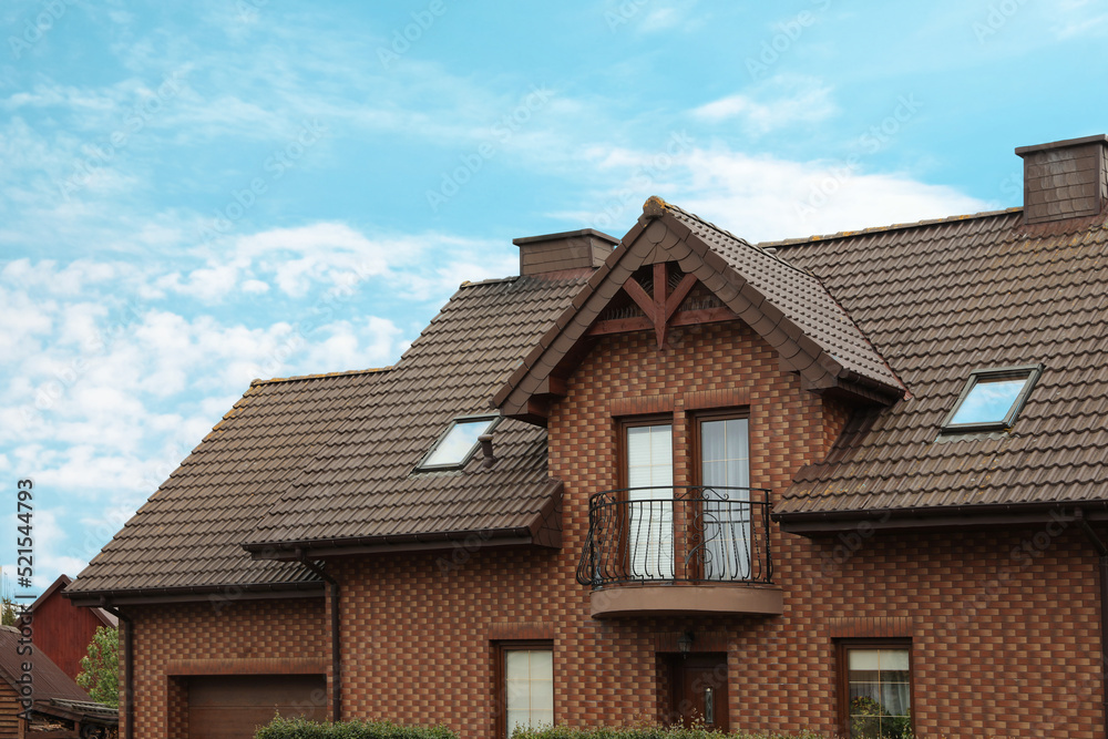 Beautiful house with brown roof against blue sky Beautiful house with brown roof against blue sky