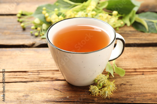 Cup of tea and linden blossom on wooden table