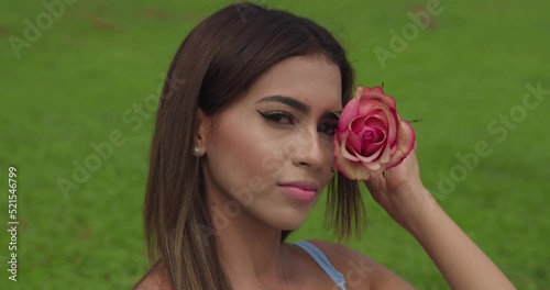 Close up of a young girl holding a flower to her face at the park photo