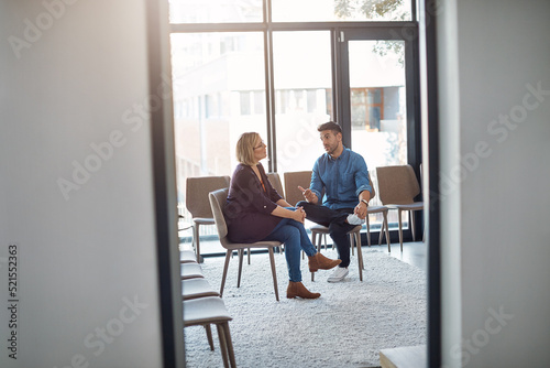 Business man in a job interview with a businesswoman talking about hiring and recruitment. An HR manager and employee sitting and having a discussion or meeting in a modern office or workplace