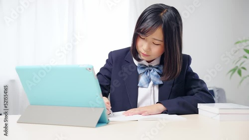 タブレットを見ながら勉強する女子学生　オンライン授業　eラーニング photo