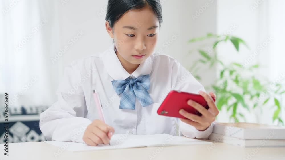 スマホを見ながら勉強する女子学生 オンライン授業 eラーニング スマホを見ながら勉強する女子学生 オンライン授業 eラーニング