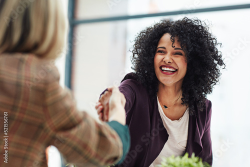 Handshake with a happy, confident and excited business woman or human resources manager and a female colleague, partner or employee. An agreement, deal or meeting with a coworker in the boardroom photo