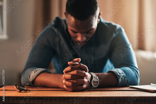 Fotografie, Obraz Quiet, calm and spiritual man praying while kneeling with his hands clasped alone at home