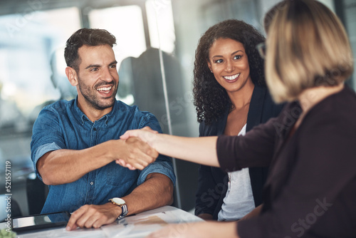 Handshake and teamwork by business people, colleagues and coworkers in a meeting, discussion or negotiating at work. Corporate professionals greet, make a deal and collaborate in an office boardroom