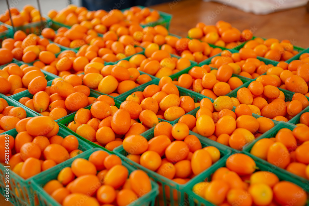 A view of several cartons of kumquats, on display at a local farmers market.