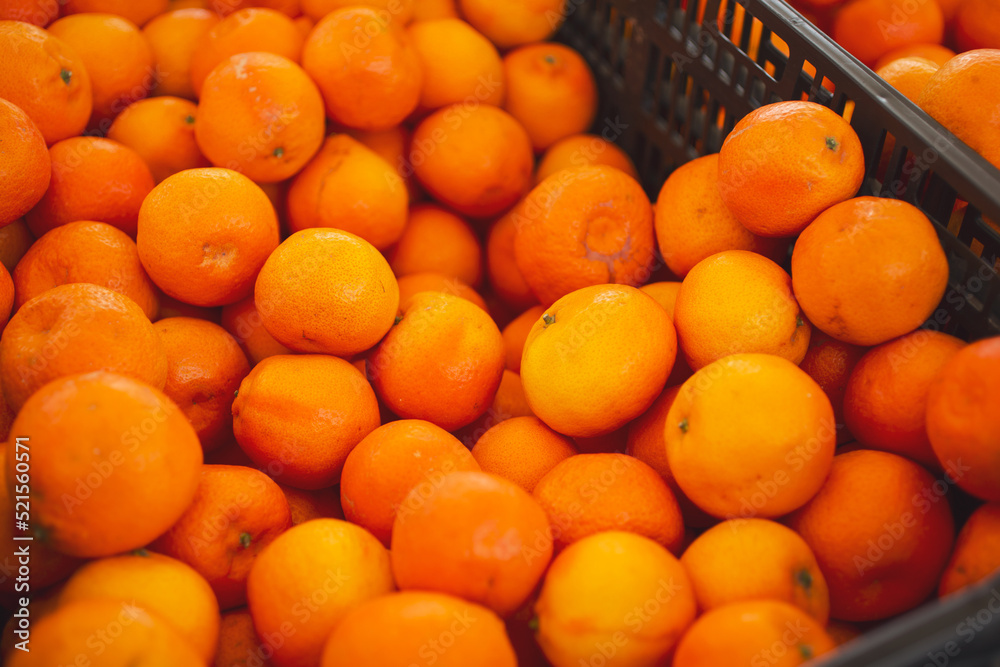 A view of a crate full of tangerines, on display at a local farmers market.
