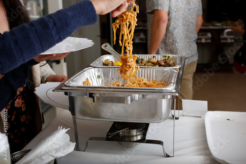 Valokuva A view of several chafer dishes filled with savory entrees, seen at a local catered event