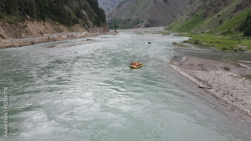 Drone flying over Kunhar river while tourists enjoy river rafting in the boat, Kunhar is located in Kaghan valley (Pakistan). This valley is a popular summer destination for domestic tourists. 