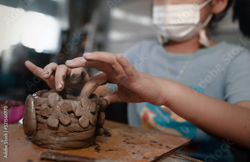 Little Asian girl creating potter clay bowl at home.Education,hobby and handicraft concept.