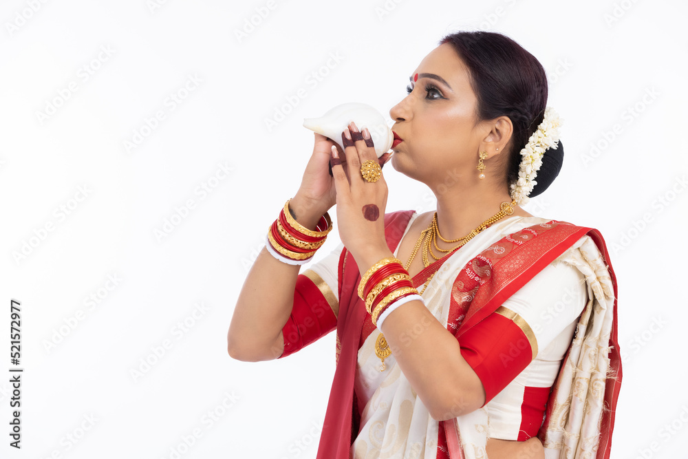 Bengali woman blowing on a conch shell Bengali woman blowing on a conch shell