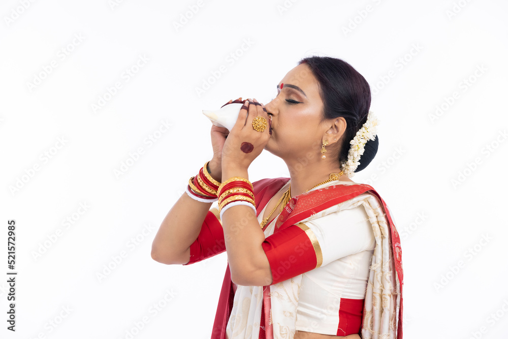 Bengali woman blowing on a conch shell Bengali woman blowing on a conch shell