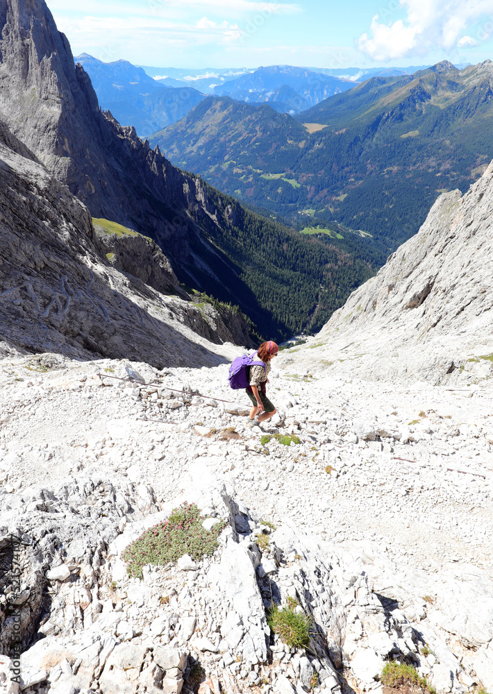 girl going down the mountain path to reach the South Tyrol valley in Italy