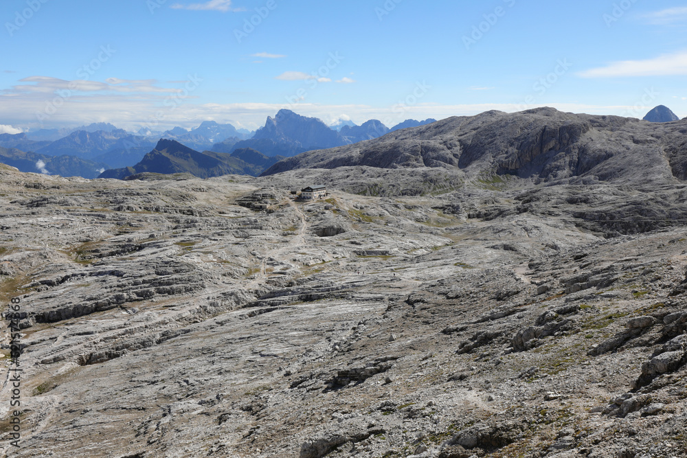 Plateau that looks like a lunar landscape with the paved rock on the Dolomites and the Alpine Refuge