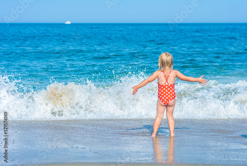 A small girl is enjoying ocean waves