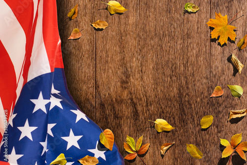 little flag of USA with maple leaves on wooden table. Above view. photo