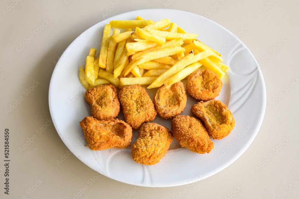 Fried Chicken breast hot crispy strips crunchy chicken tenders isolated on white background.Nuggets isolated on white background on a plate Fried Chicken breast hot crispy strips crunchy chicken tenders isolated on white background.Nuggets isolated on white background on a plate