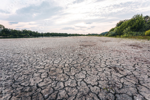 Dry lake in Bavaria Germany. Drought and climate change, landscape of cracked earth after lake has dried up in summer. Water crisis an impact of global warming.