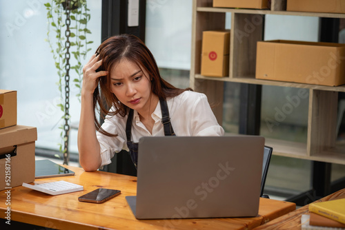 Asian businesswoman worried about unordered online sales photo