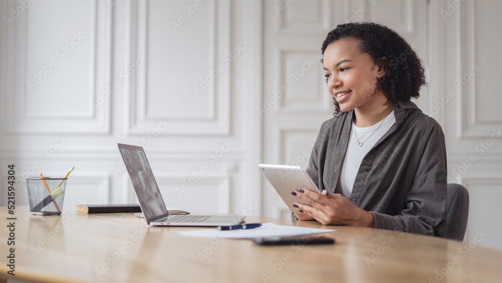 A young female student is smiling working in the office using a laptop to surf the Internet A young female student is smiling working in the office using a laptop to surf the Internet