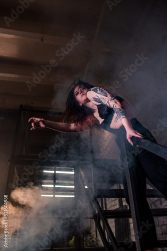 Sexy girl dance on front of spot light wall with smoke