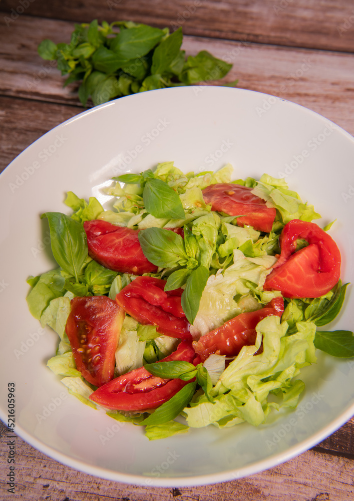 Green vegan salad, tomato and basilic from green leaves mix and vegetables, High quality photo