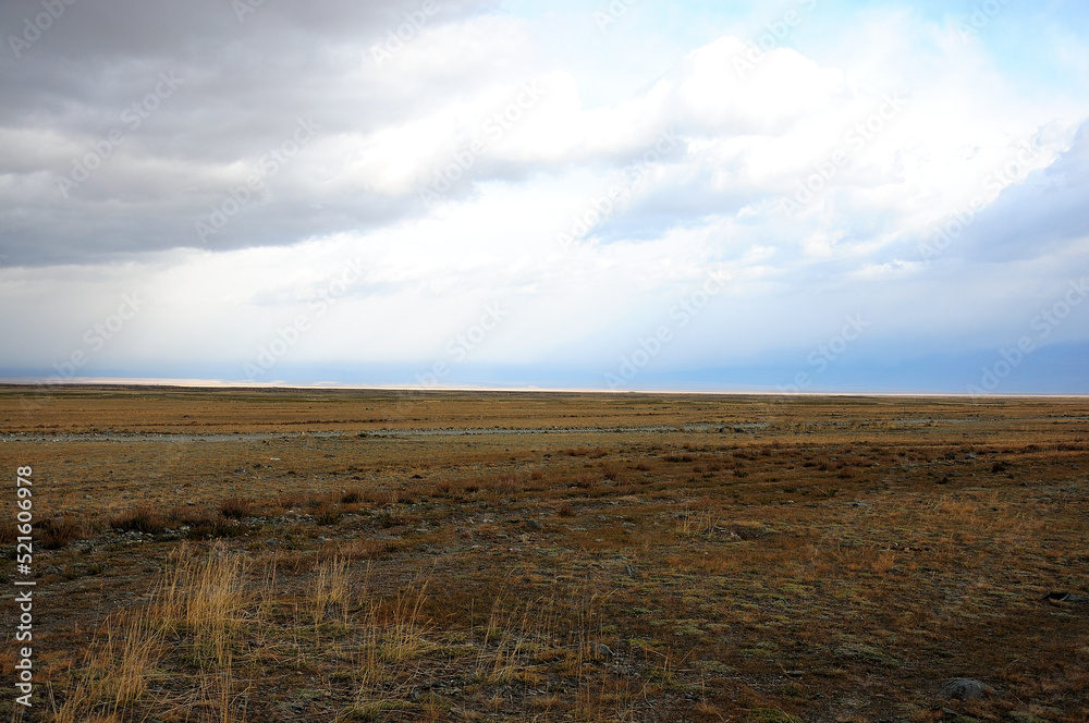 Flat and boundless steppe under the autumn cloudy sky. Flat and boundless steppe under the autumn cloudy sky.