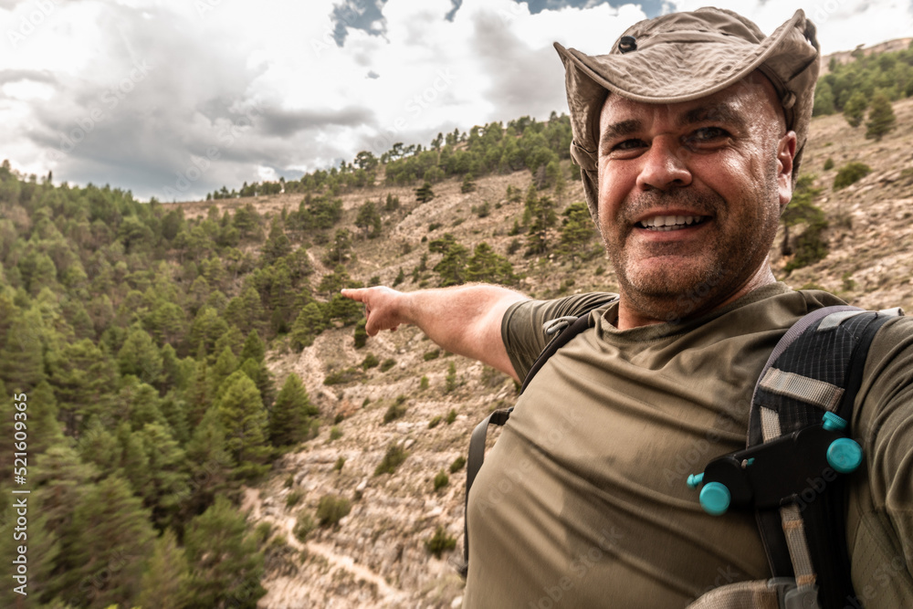 Adventurous male hiker takes a selfie pointing the way