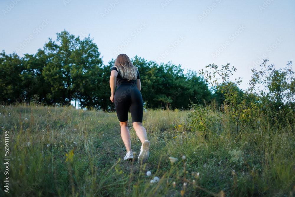 girl fitness blonde climbs a mountain along a path in the park girl fitness blonde climbs a mountain along a path in the park
