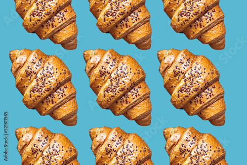 Many fresh plain croissants on a blue background.. French breakfast