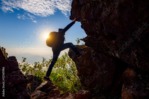 Young asian couple climbing up on the mountain,hiking and team work concept.