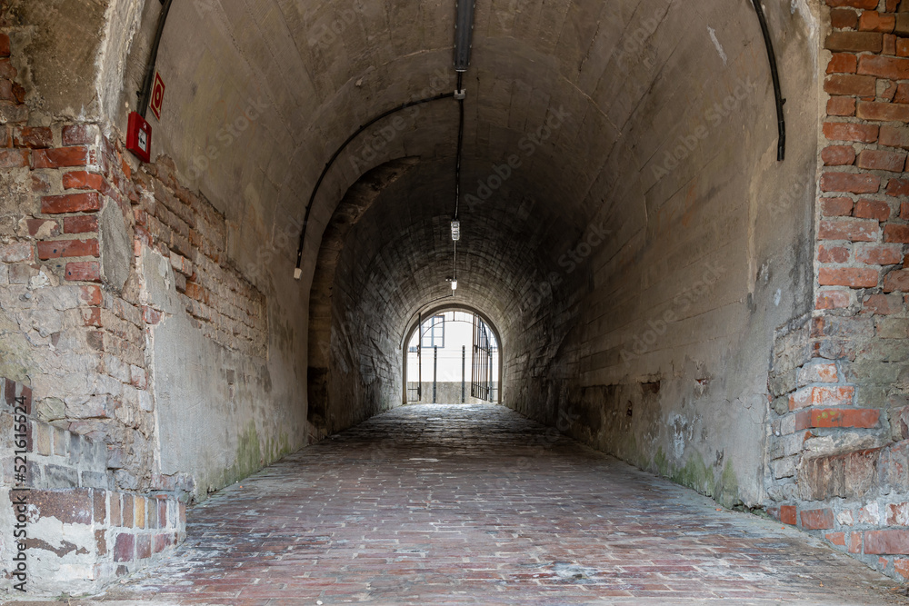 Tunnel through the fortification in the old town of Zamość. Barrel vault. Brick walkway. Zamosc, Poland