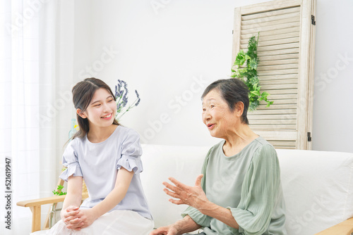 自宅で会話する孫と祖母