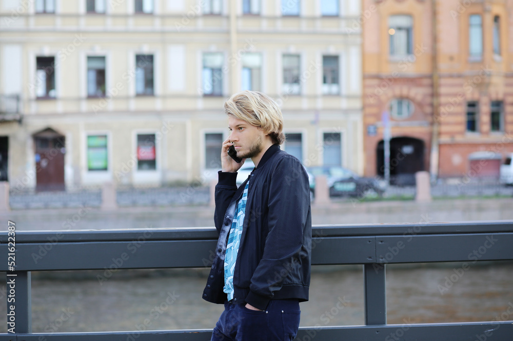 Lifestyle portrait of young man using a smartphone outdoors.