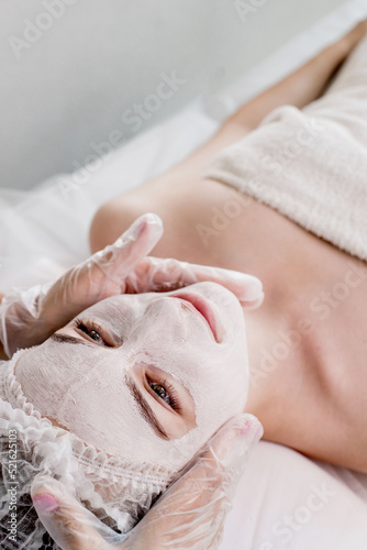 Woman in moisturizing anti-wrinkle mask. A woman is lying down, resting in a beauty salon. SPA procedures at home or in a cosmetology center