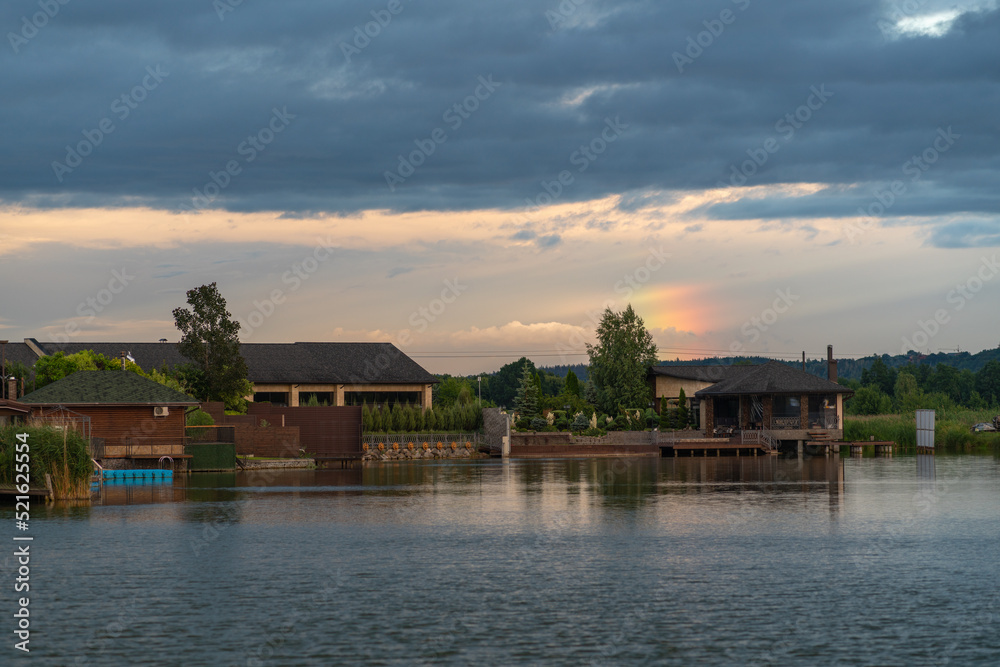 Luxury houses on the shore if a tranquil lake at sunset