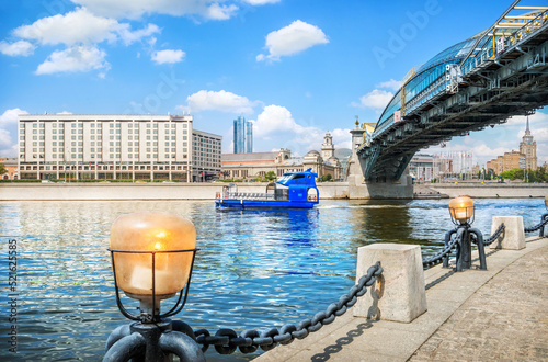 Pleasure ship of blue color on the Moskva River and Bogdan Khmelnitsky bridge, Moscow