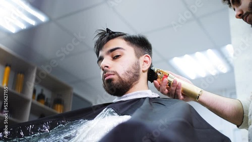 Men's haircut with an electric razor in a barber shop.