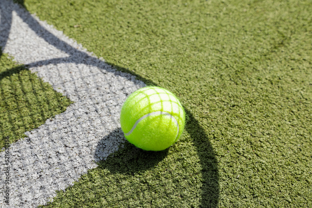tennis ball on the court, shadow of a tennis racket on the floor, no person