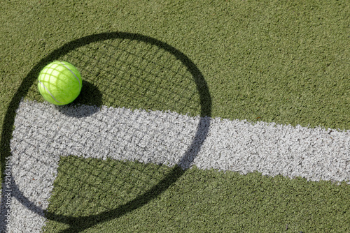 tennis ball on green grass, shadow of the tennis racket, white line as a corner