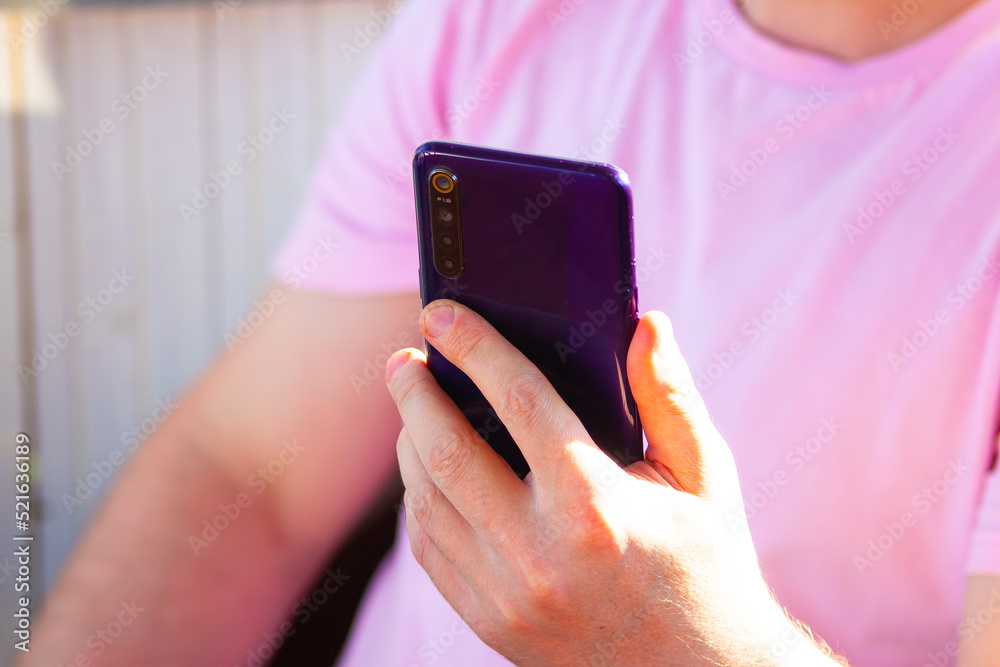 Fototapeta premium A man in pink watches technology news in nature