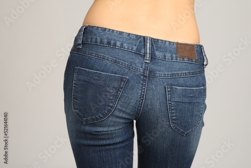 Body and ass of girl in jeans close-up. Woman in denim pants back view. Woman with bare back. Hips of slim girl in denim pants back view. Fashion femininity concept. Casual wear for woman.