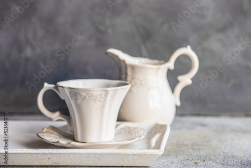 Porcelain tea cup on a tray with a milk jug photo