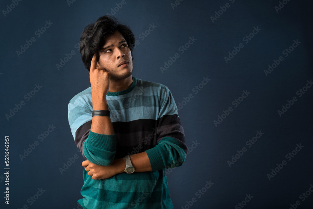 Portrait of a young man thinking on a dark background Portrait of a young man thinking on a dark background