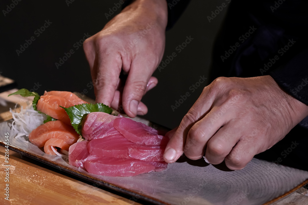 Close-up of a Japanese chef preparing to cook Japanese food. Make sushi at a traditional Japanese restaurant on a chopping board.