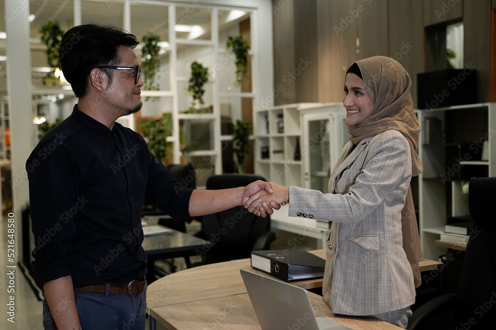 Fototapeta premium Muslim men and women shaking hands in business