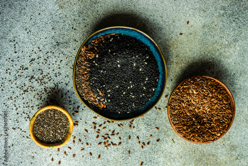Overhead view of three bowls with chia seeds, flax seeds and sesame seeds photo