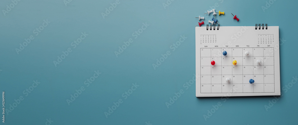 Embroidered red pins on a calendar event Planner calendar,clock to set timetable organize schedule,planning for business meeting or travel planning concept. - obrazy, fototapety, plakaty 