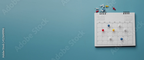 Embroidered red pins on a calendar event Planner calendar,clock to set timetable organize schedule,planning for business meeting or travel planning concept. photo