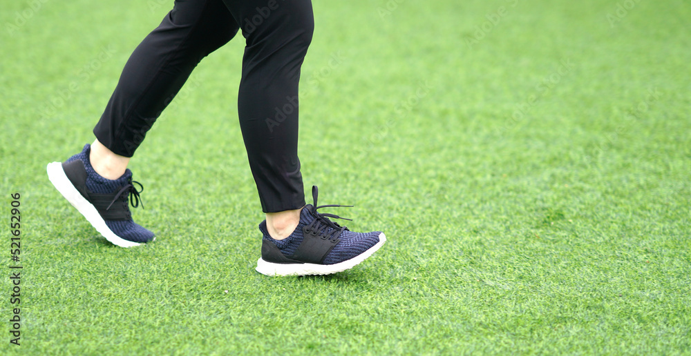 woman wearing sports shoes jogging run in the lawn woman wearing sports shoes jogging run in the lawn